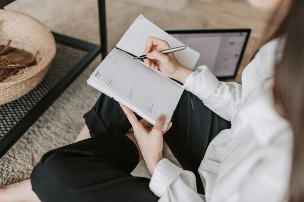 A woman writing on a planner